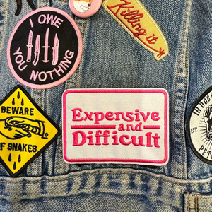 expensive and difficult pink and white embroidered patch on denim jacket. 